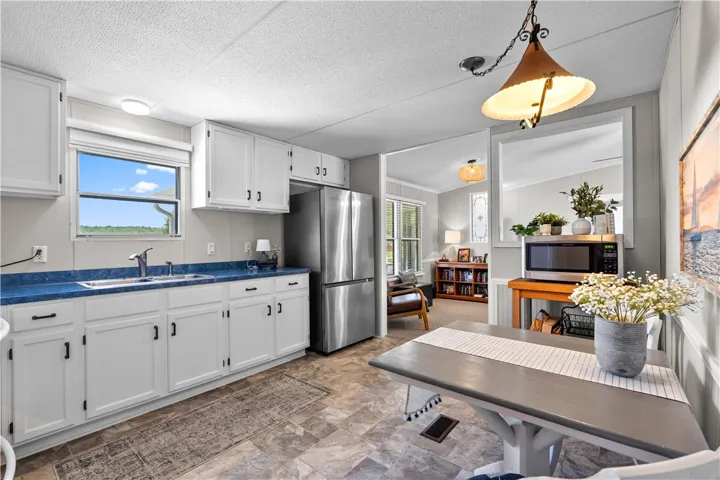 A well-lit kitchen with ample white cabinetry and convenient access to the adjoining living space.