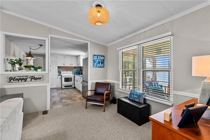 Natural light floods this living area with a kitchen passthrough, offering serene water views from the window.