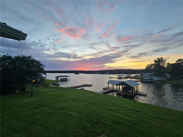 Witness magnificent sunsets over the tranquil lake from this verdant hillside property, complete with private boat dock.