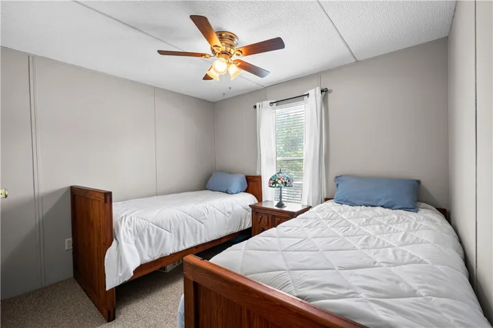 Two comfortable beds flank a window, creating a serene and well-lit sleeping area.