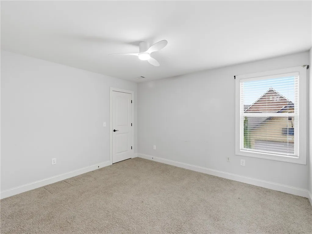 A well-lit bedroom with soft carpeting provides a serene and inviting personal retreat.