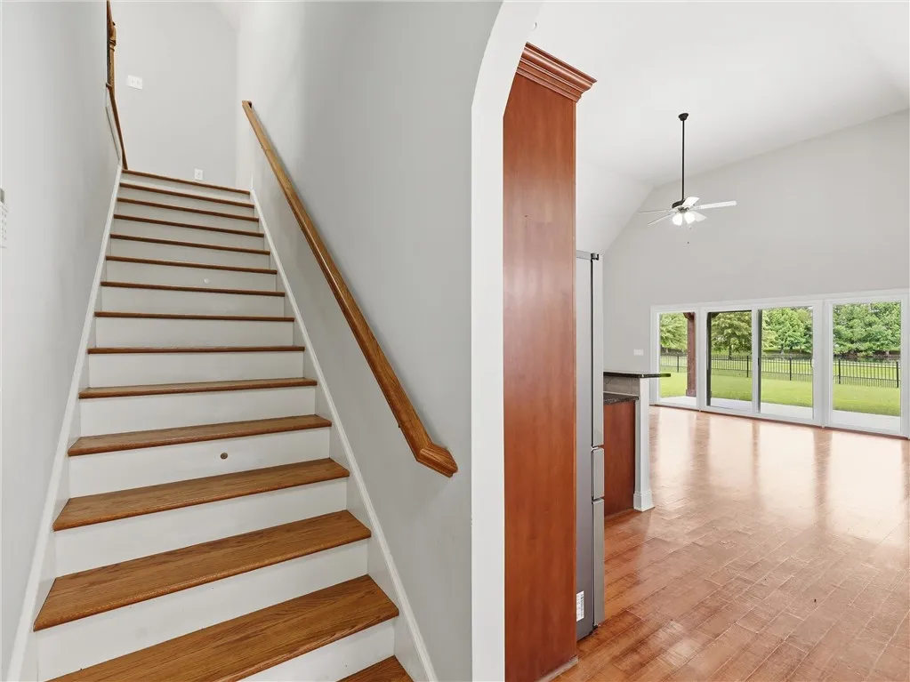 Hardwood floors complement the vaulted ceilings and sun-filled patio access in this inviting space.