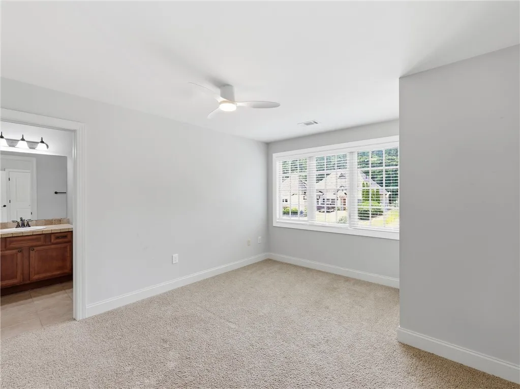 A well-lit bedroom with soft carpeting and an adjoining vanity area, offering a tranquil retreat.