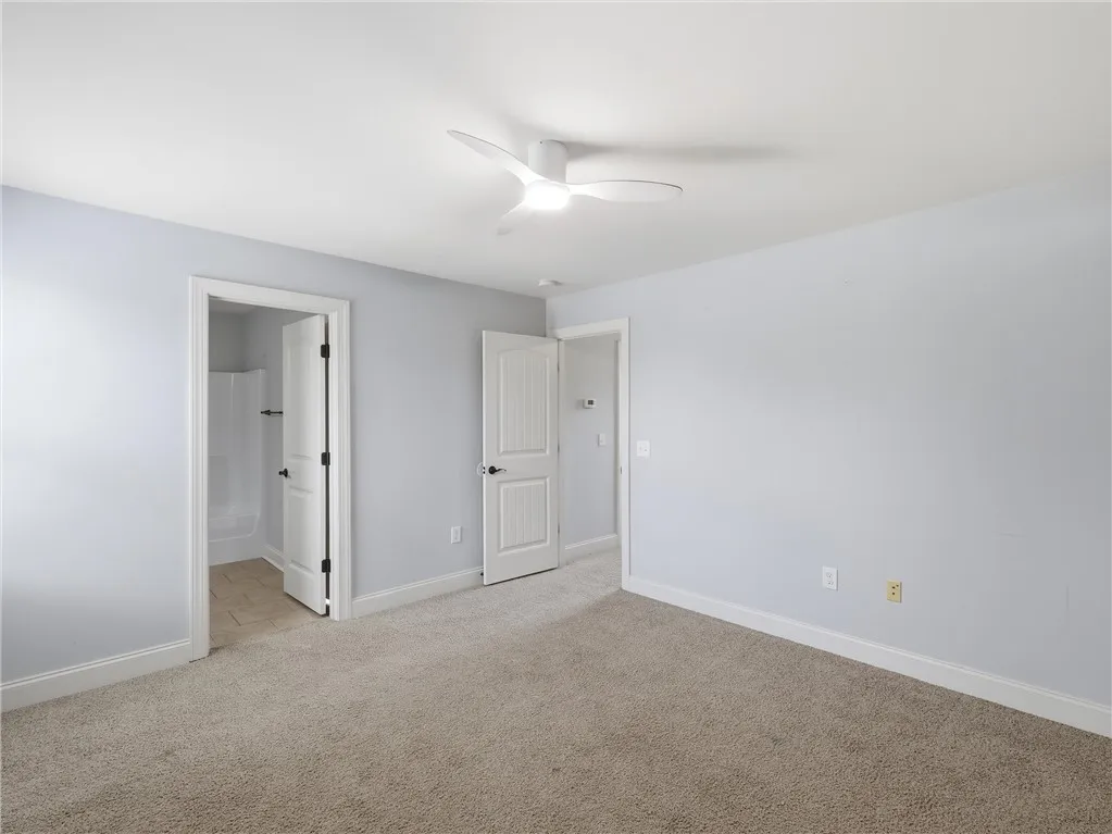 Well-lit and spacious, this room boasts soft carpeting and convenient access to an adjoining bath.