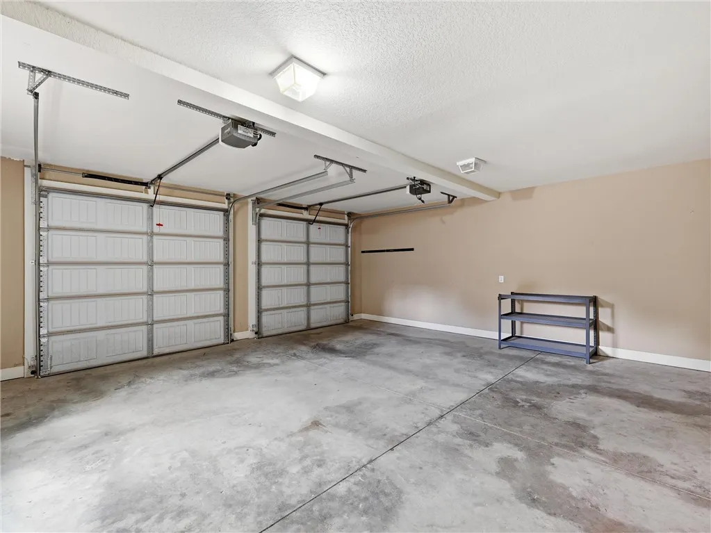 A spacious garage with two overhead doors provides ample vehicle accommodation and storage potential.