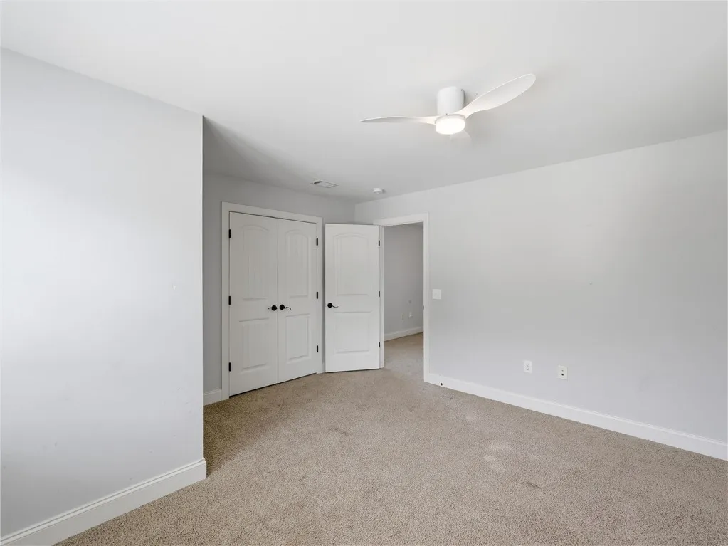 A quiet retreat with plush carpeting and modern ceiling fan for ultimate comfort.
