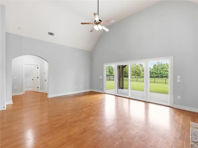 Bright hardwood floors and a soaring vaulted ceiling define this inviting living space, offering tranquil backyard views.