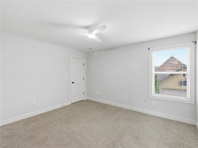 A well-lit bedroom with soft carpeting provides a serene and inviting personal retreat.