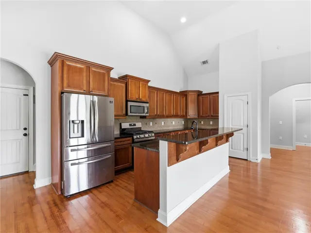 Prepare meals in this kitchen featuring high ceilings and a substantial granite island with additional seating.