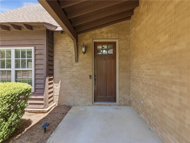 A welcoming wooden entry door framed by sturdy brick, hints at inviting interiors.