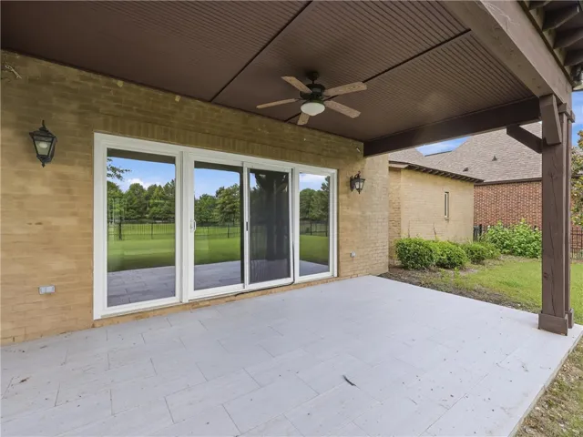 A spacious, tiled patio with a cooling fan provides a peaceful outdoor retreat.