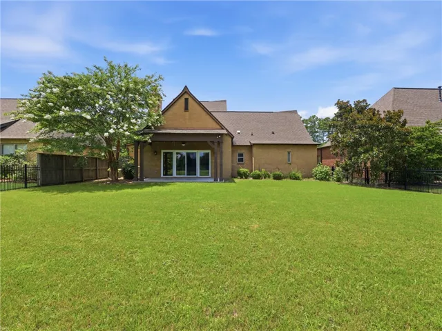 A private, grassy yard extends from the home's rear patio, perfect for outdoor living.