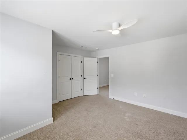 A quiet retreat with plush carpeting and modern ceiling fan for ultimate comfort.