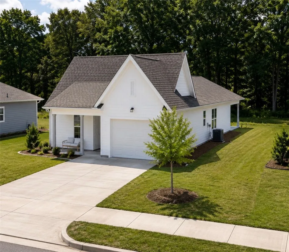 A well-maintained lawn and concrete driveway welcome you to this charming single-story residence.