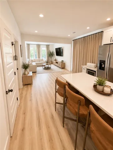 An inviting open-concept layout features rich hardwood flooring and recessed lighting throughout.