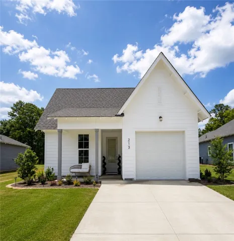 A classic facade with a covered entry and attached garage offers delightful curb appeal.