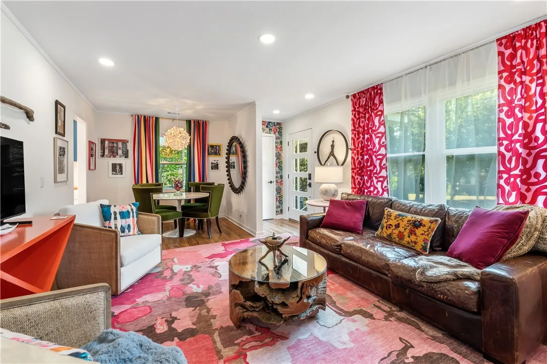 Recessed lighting illuminates an inviting living area with rich hardwood flooring and a charming dining space.