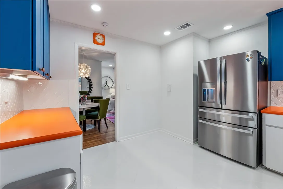 A vibrant kitchen features glossy floors, lively cabinetry, and contemporary appliances.