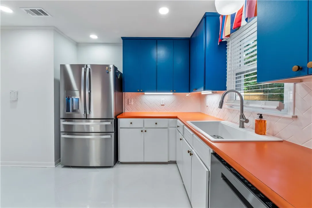 Bold cabinetry and vivid countertops define this inviting and modern culinary space.