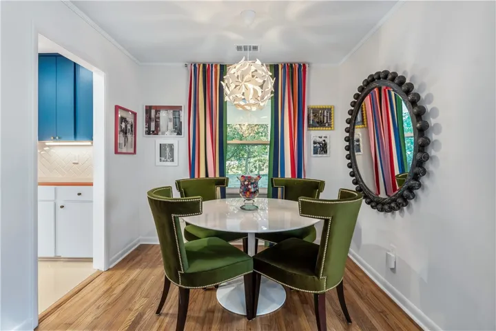 Hardwood floors and a stylish chandelier define this inviting dining space, ideal for lively gatherings.