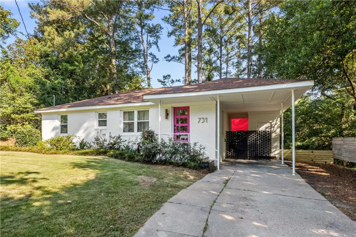 A vibrant fuchsia door welcomes you to this classic single-story residence with an attached carport.