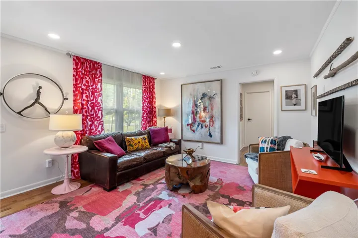 Sun-filled living space featuring gleaming hardwood floors and recessed lighting.