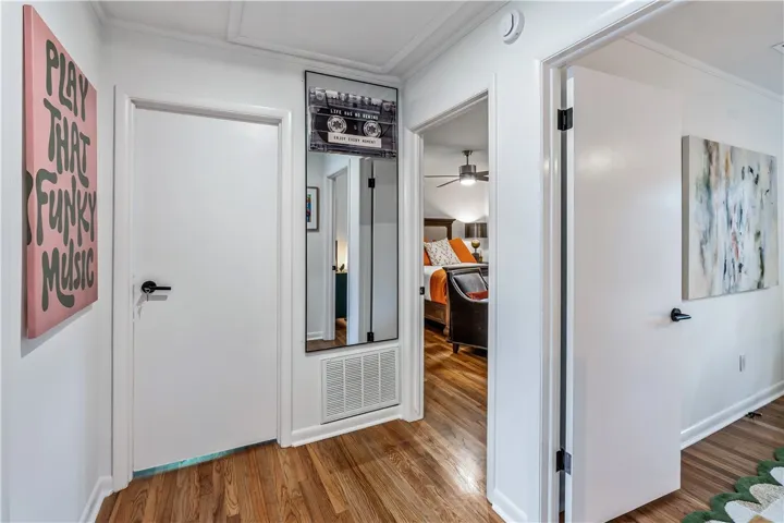 Rich hardwood floors welcome you into a corridor connecting inviting living spaces.
