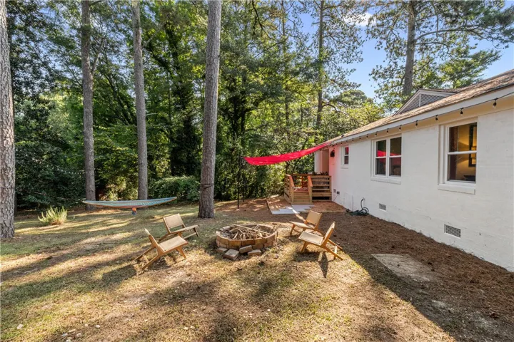 A secluded backyard sanctuary with a fire pit and a private deck, perfect for peaceful evenings.