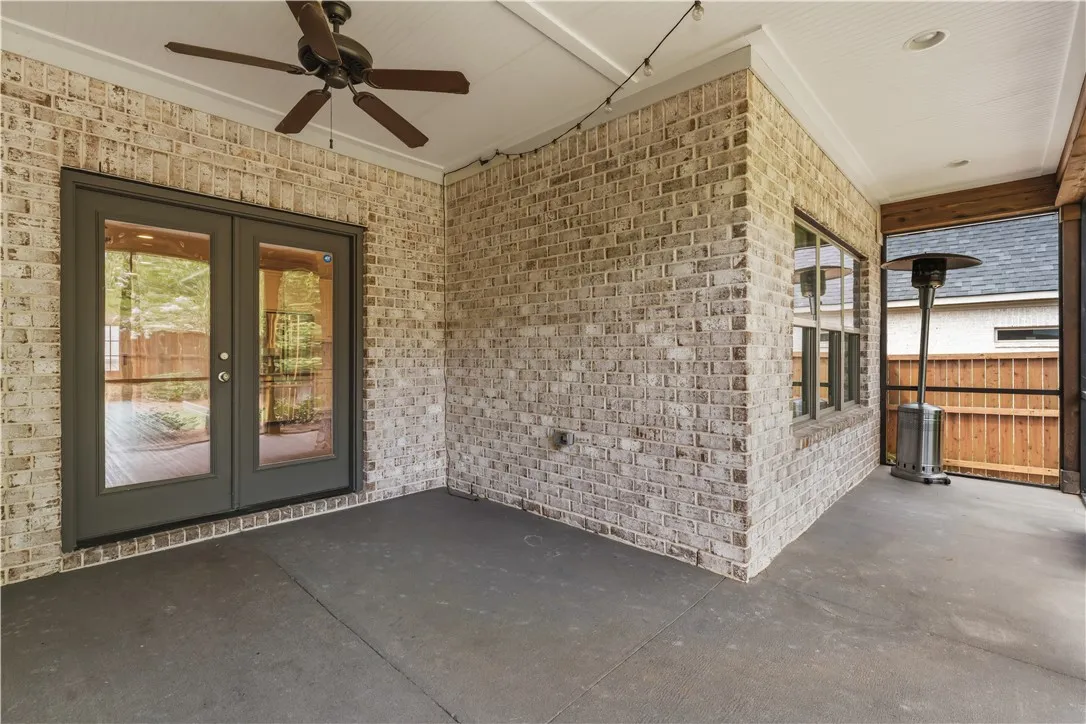 A spacious covered patio offers ample room for outdoor relaxation, featuring elegant French doors.