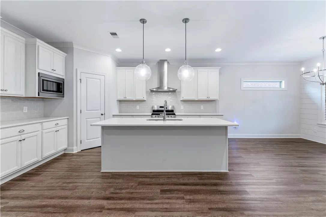 Culinary aspirations come alive in this well-appointed kitchen, boasting rich wood flooring and a central island.