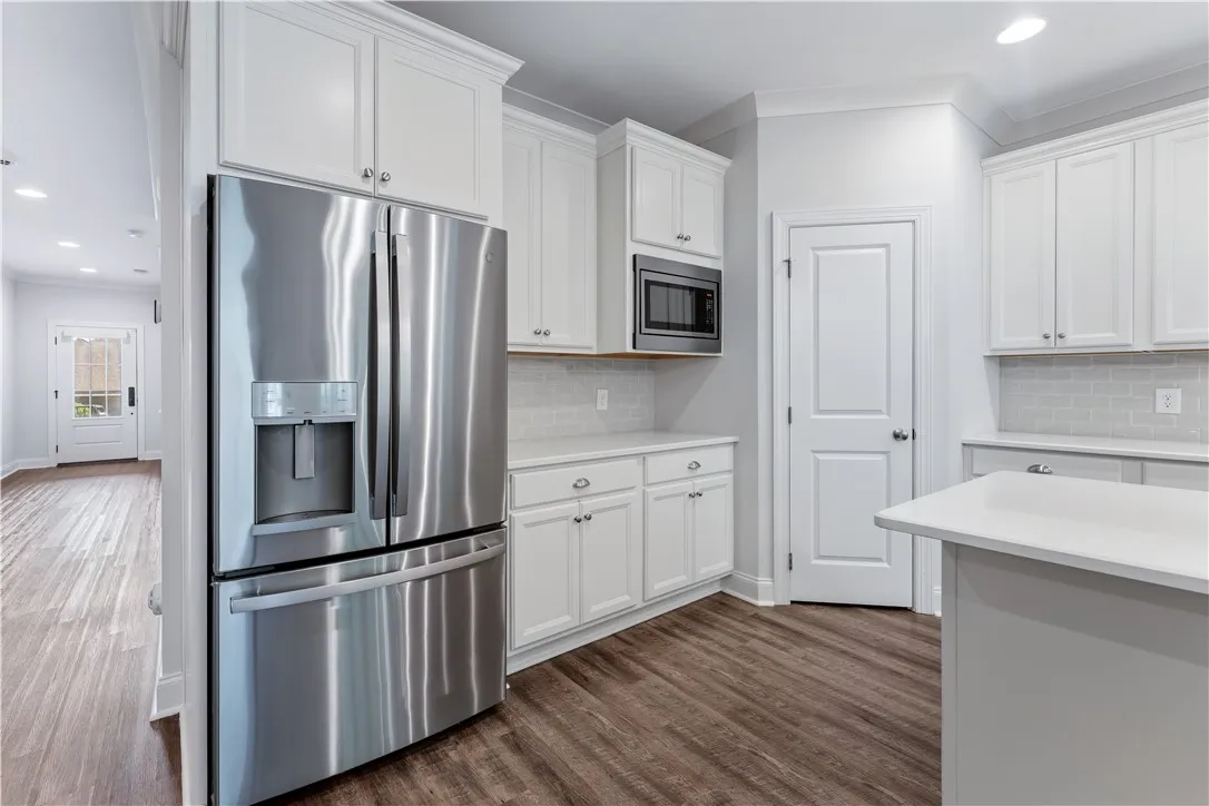 A clean, functional kitchen featuring pristine white cabinetry and contemporary appliances.
