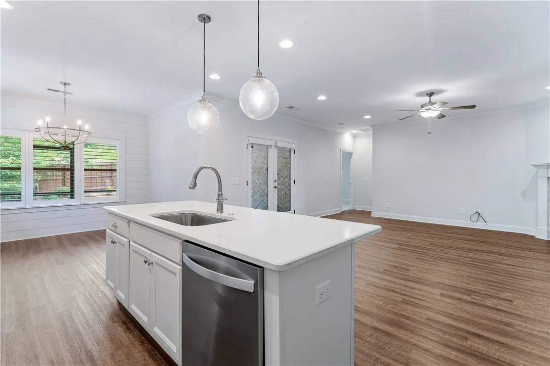 A well-appointed kitchen island anchors this open-concept living space, featuring rich hardwood floors.