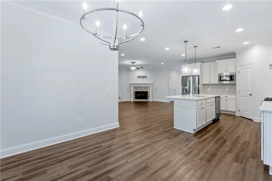 An open floorplan seamlessly connects the kitchen and living area, highlighting a central island and a cozy fireplace.