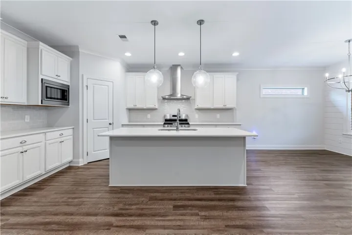 Culinary aspirations come alive in this well-appointed kitchen, boasting rich wood flooring and a central island.
