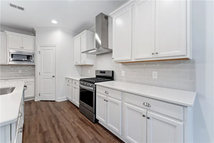 A well-equipped culinary space boasts ample white cabinetry and sleek stainless steel appliances.