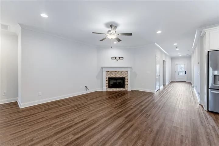A welcoming living area boasts rich hardwood-style flooring and a charming tiled fireplace focal point.