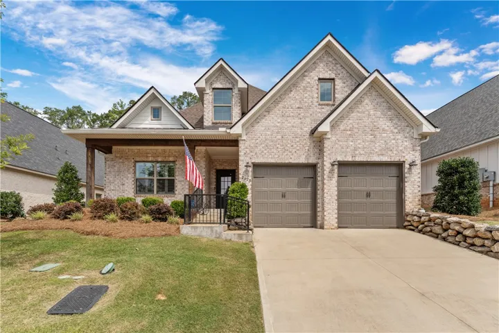 A charming brick exterior with a welcoming porch and a two-car garage awaits.