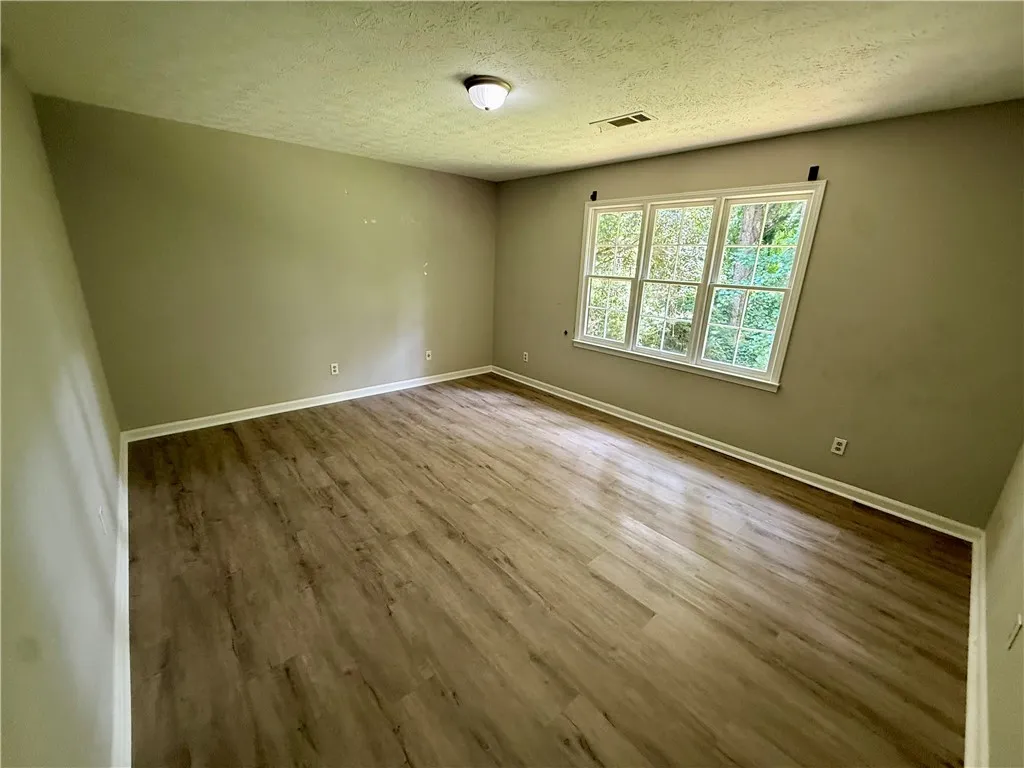 An airy room offers views of lush greenery through ample windows.