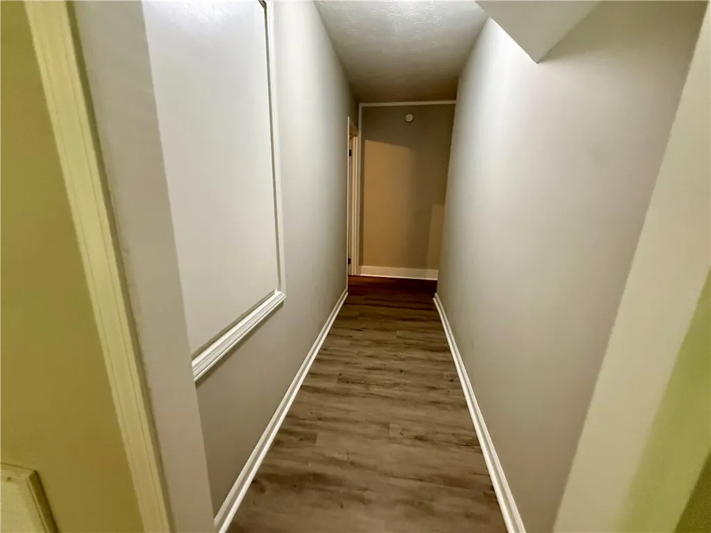 A well-maintained hallway with durable wood flooring guides you through this residence.