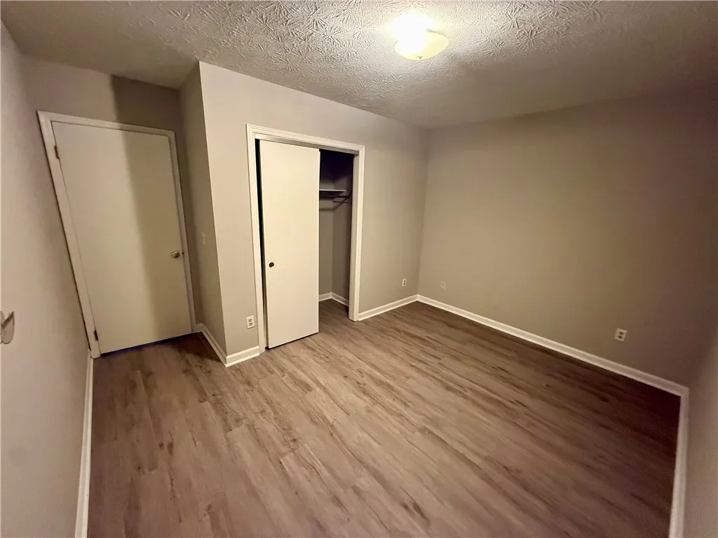 Newly installed wood flooring spans this cozy bedroom, offering comfort and style.