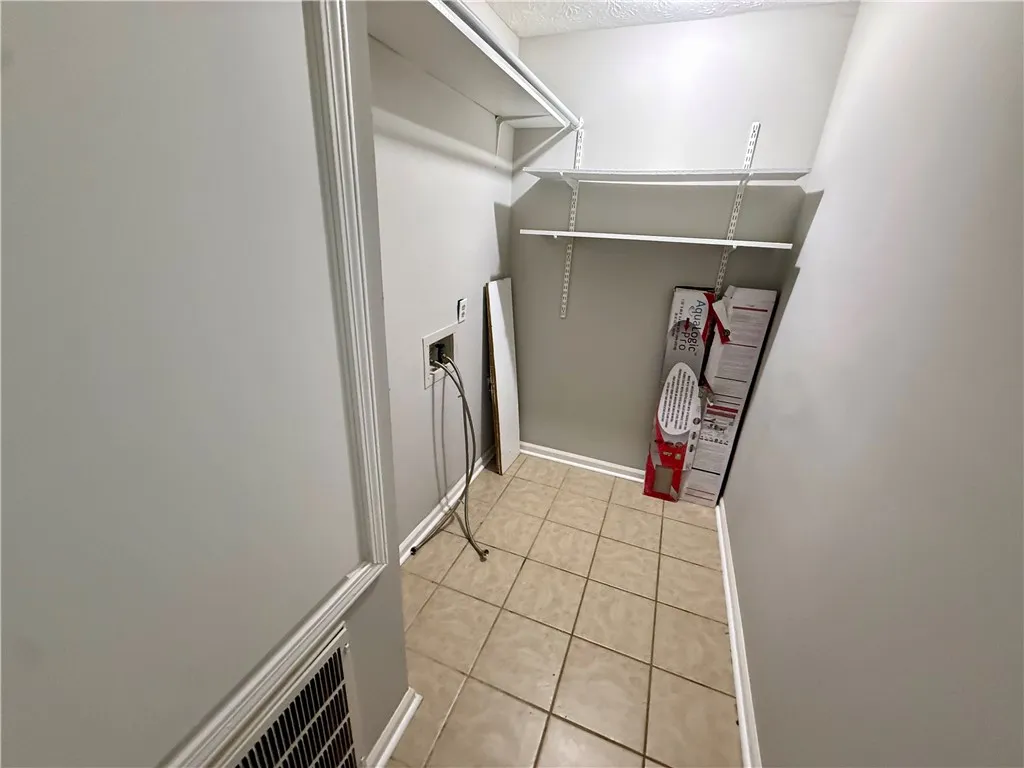 A dedicated utility space with practical shelving and durable tile flooring awaits customization.