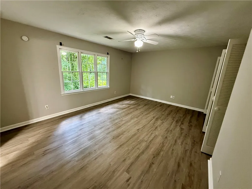 Natural light pours into this spacious room, highlighting the beautiful wood flooring.