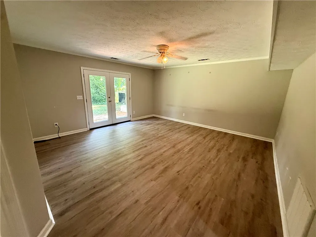 French doors open to an adaptable living space with durable flooring.
