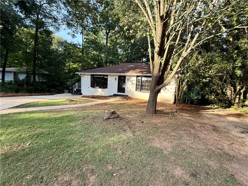 A classic ranch home nestled among mature trees offers privacy and a peaceful setting.