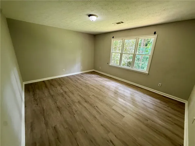 An airy room offers views of lush greenery through ample windows.