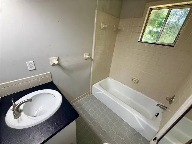 This bathroom features a sleek sink with brushed nickel fixtures and durable tile flooring.