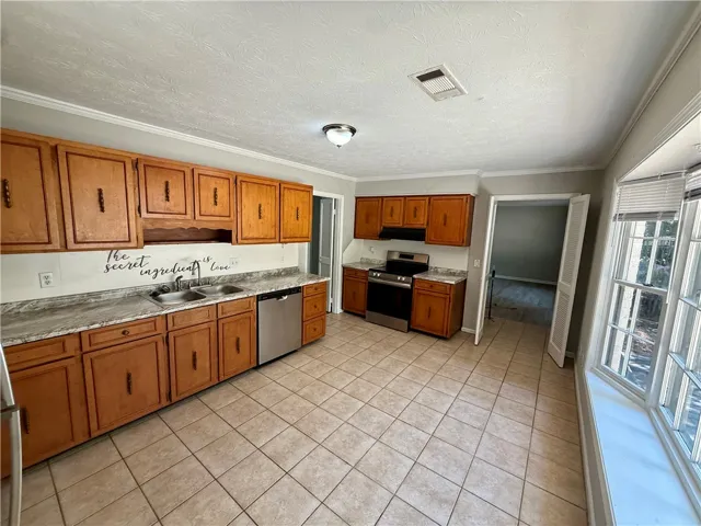 A well-appointed kitchen featuring abundant wood cabinetry and durable tiled flooring.