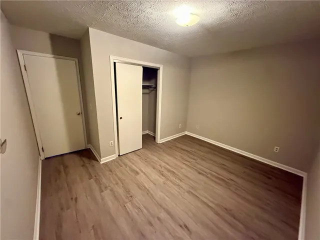 Newly installed wood flooring spans this cozy bedroom, offering comfort and style.