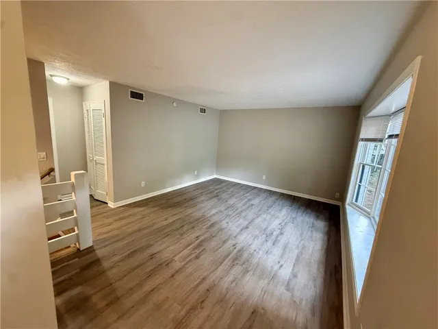 A spacious living area with resilient flooring and natural light from a bay window.