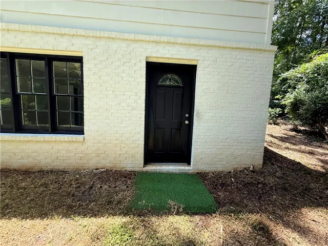 A classic brick exterior with dark trim and a decorative glass front entry offers appealing curb appeal.